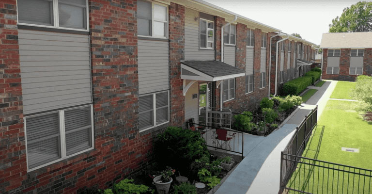 Eenced apartment complex in Yukon, OK, showcasing a lush lawn