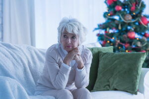 A senior woman during the holidays, representing mental health challenges and connection needs